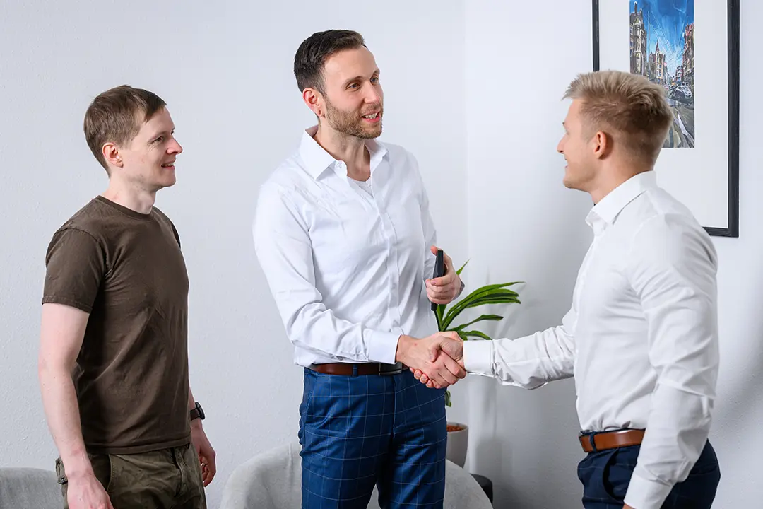Geschäftspartner begrüßen sich mit Handschlag im Büro.